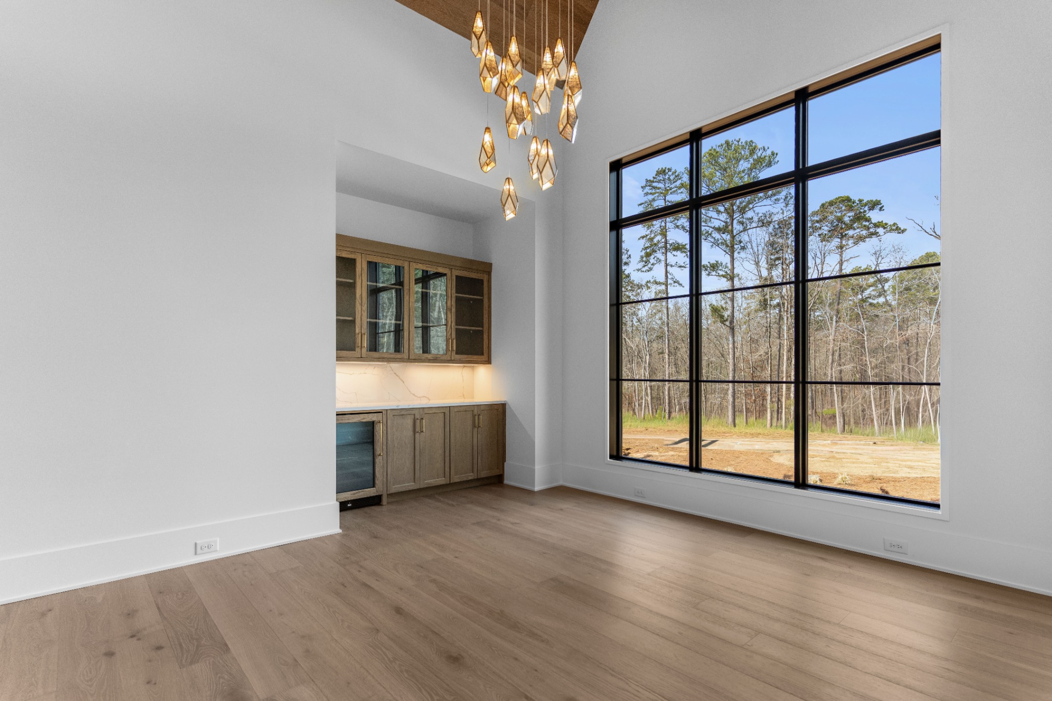 Dining room with a wooded view and wet bar with glass-front cabinets